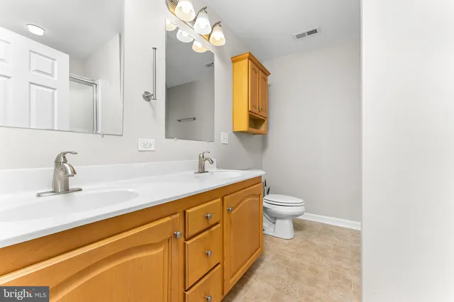 a bathroom with a granite countertop sink a toilet and a mirror