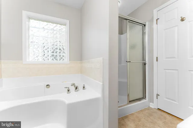a bathroom with a tub a sink and a window