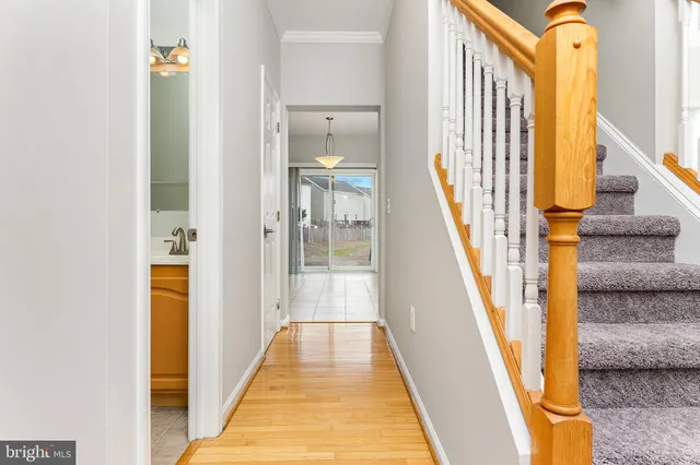 a view of a hallway with wooden floor and staircase