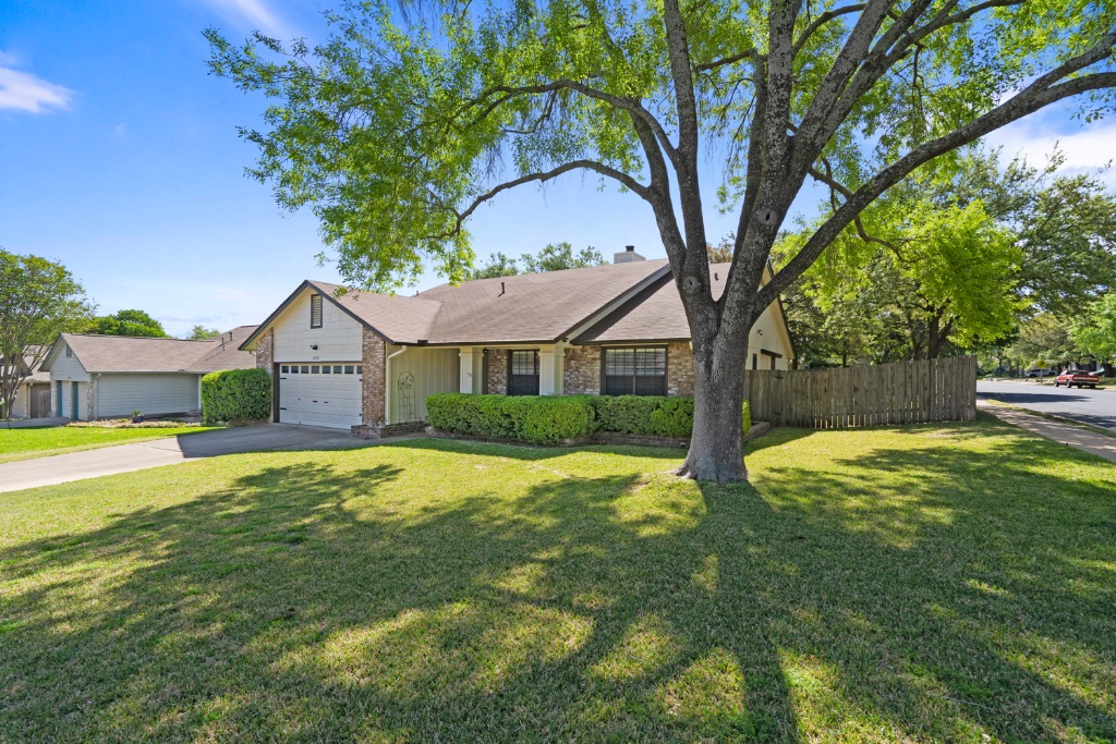 12401 Blossomwood Drive Austin, TX 78727 - Photo 1 of 1 a front view of house with yard and green space