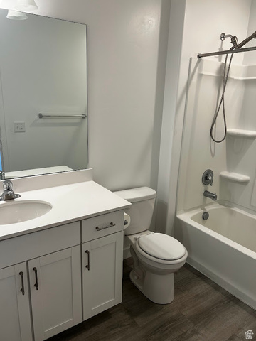 562 Hal Street, Unit 152 Tooele, UT 84074 - Photo 10 of 44 Bathroom featuring a white vanity with an integrated sink and countertop, white cabinetry with dark hardware, wood-finish flooring, and a white tub/shower combination