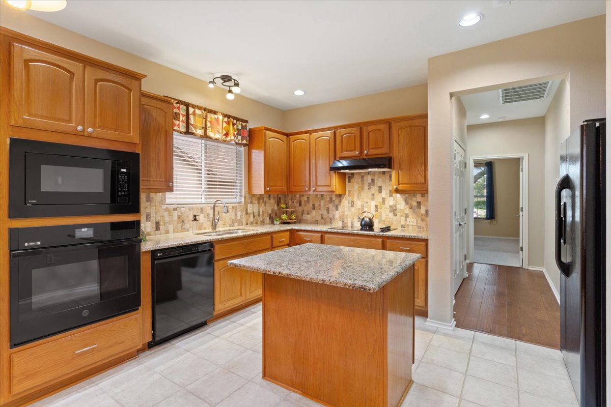 246 Red Poppy Trail Georgetown, TX 78633 - Photo 14 of 32 a kitchen with stainless steel appliances granite countertop a stove a sink and a refrigerator