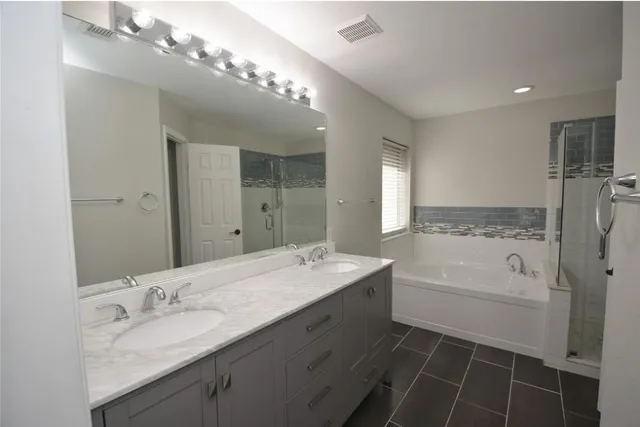 a bathroom with a sink double vanity granite tub and shower