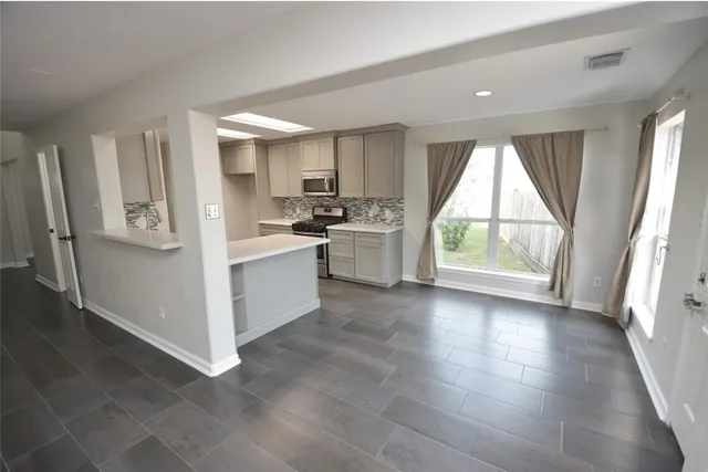 a view of a kitchen with window and wooden floor
