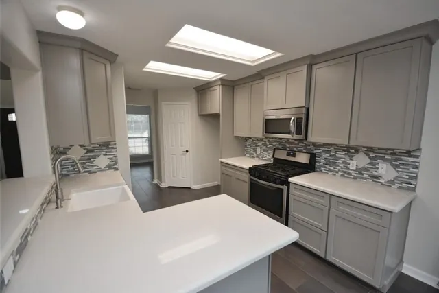 a kitchen with a sink stove and microwave