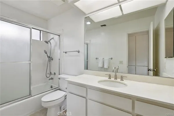 a bathroom with a double vanity sink mirror and bathtub