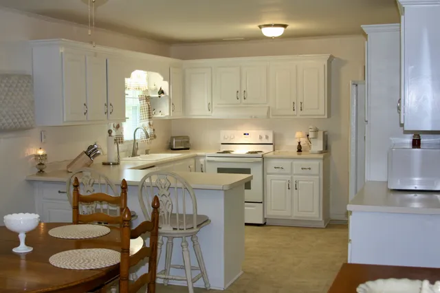 a kitchen with a sink a stove cabinets and wooden floor