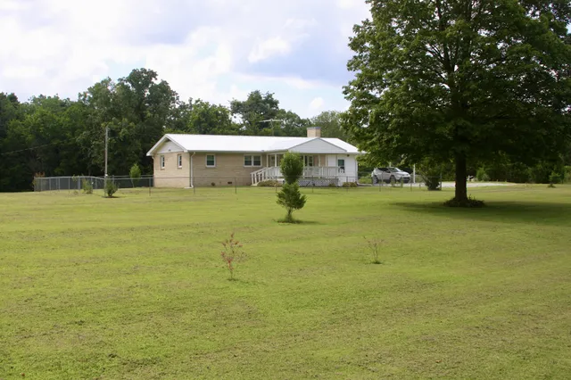 a view of a house with a yard and sitting area