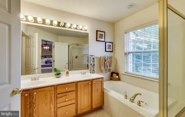 a bathroom with a tub sink and mirror
