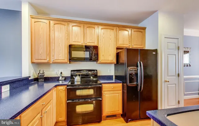 a kitchen with stainless steel appliances granite countertop a refrigerator stove and sink