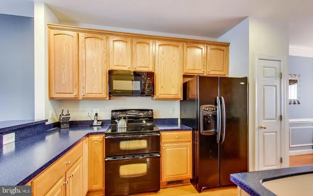 a kitchen with stainless steel appliances granite countertop a sink a stove and a refrigerator