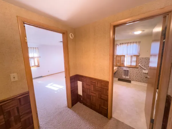 a view of a hallway and a livingroom with furniture