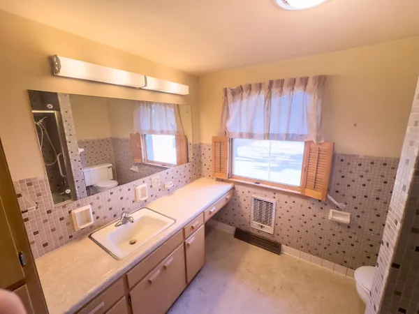 a bathroom with a tub sink and mirror