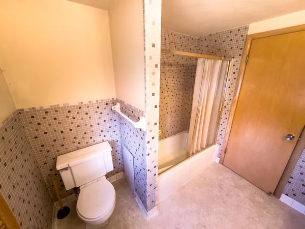 a bathroom with a toilet and a shower