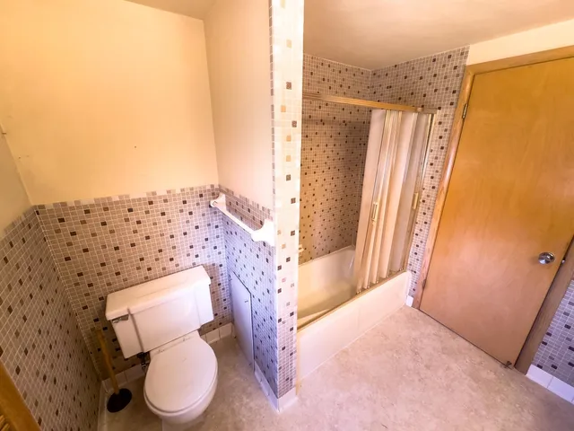 a bathroom with a toilet and a shower