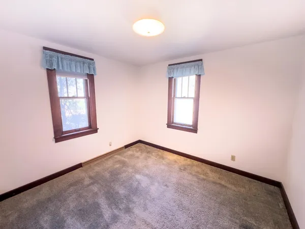 an empty room with windows and closet
