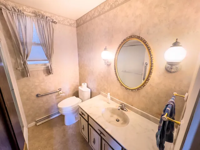a bathroom with a sink a toilet and a mirror