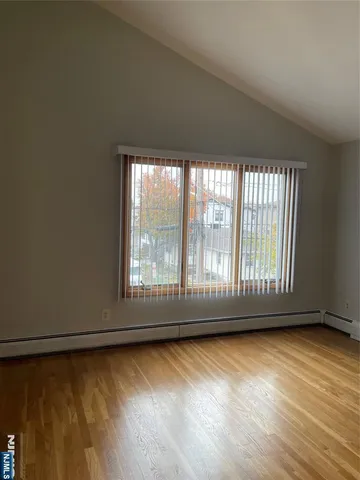 an empty room with wooden floor and a window