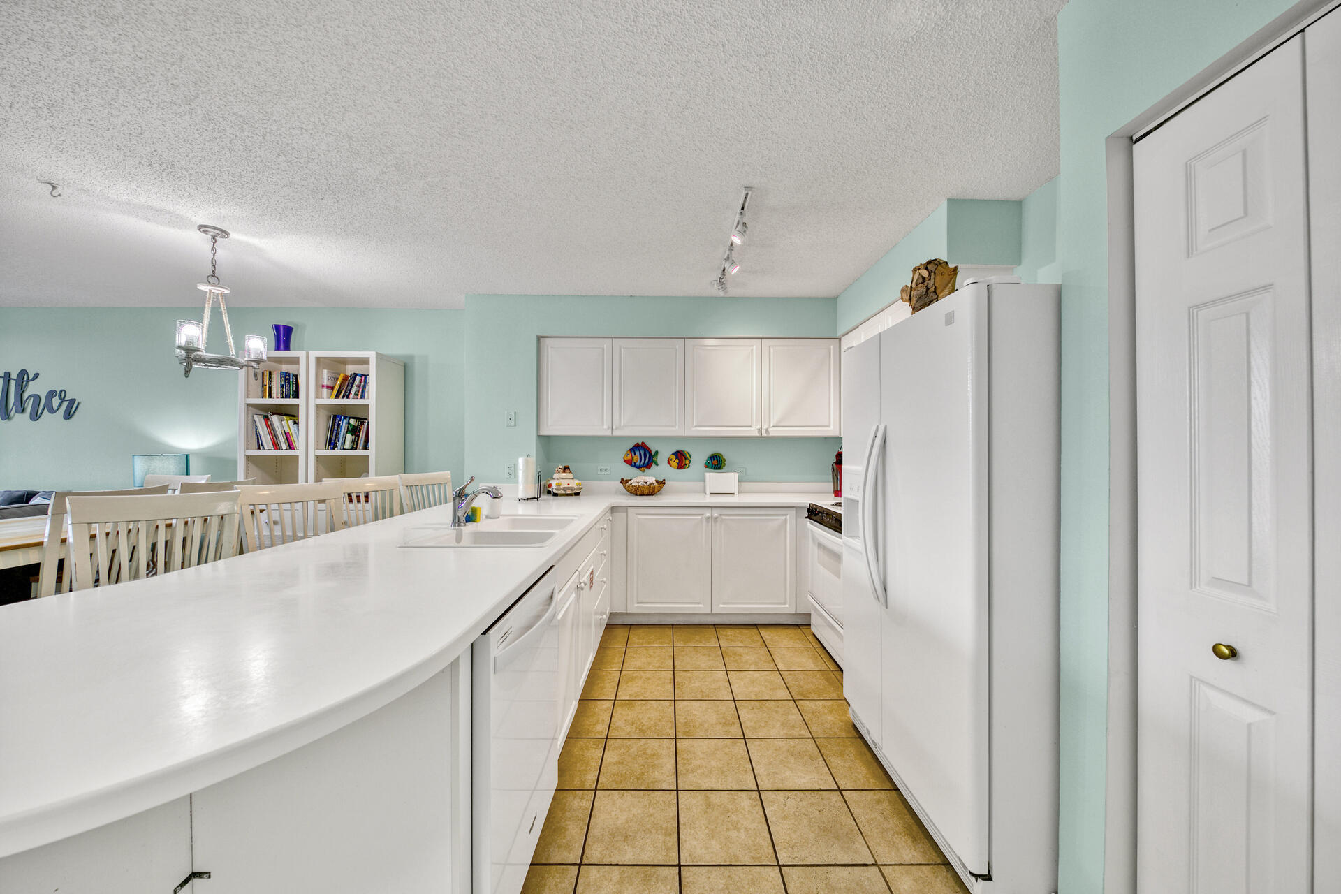 520 Santa Rosa Boulevard, Unit 111 Fort Walton Beach, FL 32548 - Photo 34 of 38 a large white kitchen with kitchen island a sink a counter top space and cabinets