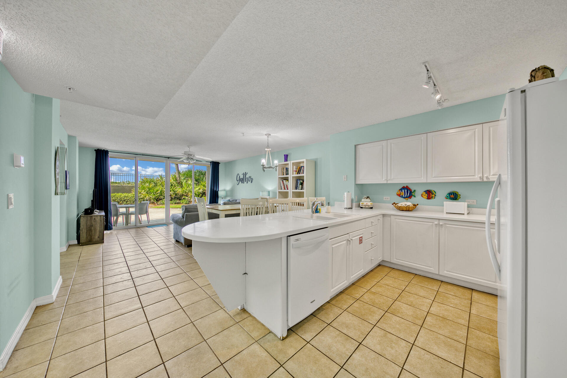 520 Santa Rosa Boulevard, Unit 111 Fort Walton Beach, FL 32548 - Photo 35 of 38 a large white kitchen with a stove a sink dishwasher and a refrigerator with wooden floor