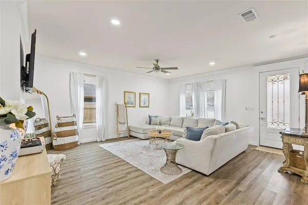 a living room with furniture and a wooden floor