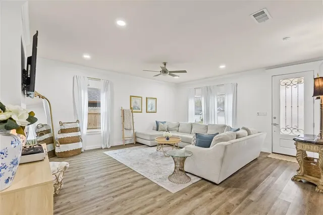 a living room with furniture and a wooden floor