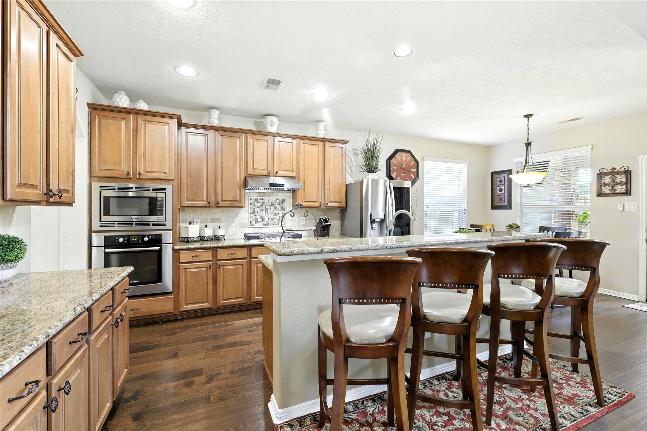 25218 Piney Heights Lane Spring, TX 77389 - Photo 11 of 40 a kitchen with granite countertop a table chairs stove a sink and dishwasher