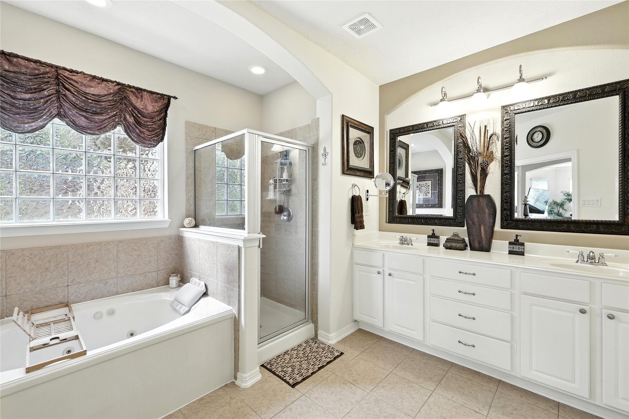 25218 Piney Heights Lane Spring, TX 77389 - Photo 19 of 40 a bathroom with a bathtub a double vanity sink and mirror