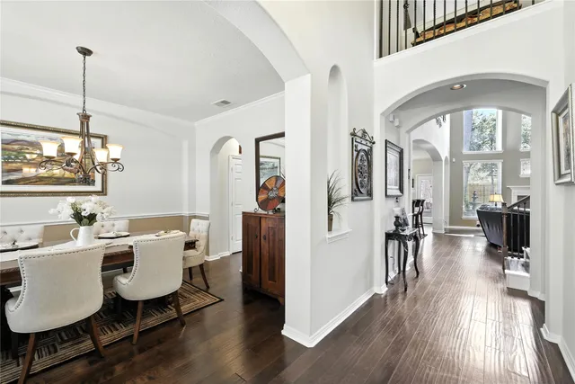 a dining room with furniture a chandelier and wooden floor