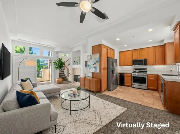 a living room with furniture kitchen view and a chandelier