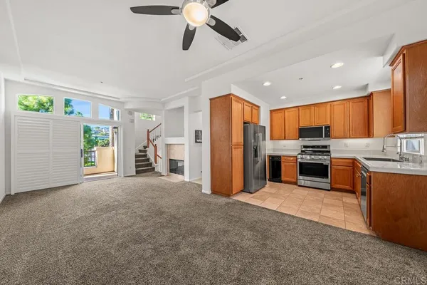 a view of kitchen with stainless steel appliances kitchen island granite countertop a refrigerator and a sink