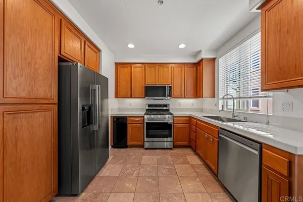 a kitchen with stainless steel appliances granite countertop a refrigerator stove top oven and sink