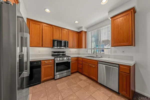 a kitchen with stainless steel appliances granite countertop a stove sink microwave and refrigerator