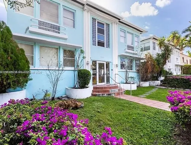 a front view of a house with a yard and fountain