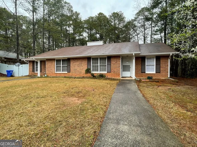 a front view of a house with yard patio and green space