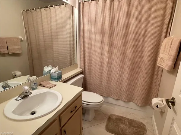 a bathroom with a sink a toilet and shower curtain