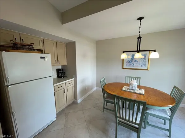 a kitchen with stainless steel appliances granite countertop a dining table chairs a refrigerator a sink a stove a dining table and chairs
