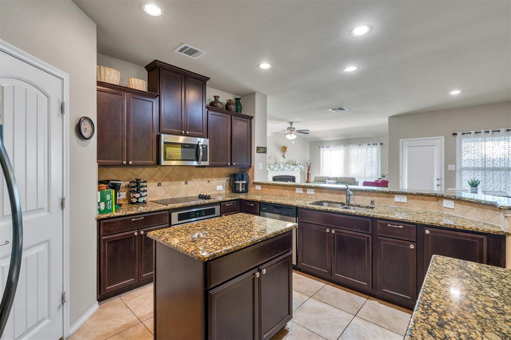 520 Rustic Oak Lane McKinney, TX 75072 - Photo 13 of 37 a kitchen with a stove sink and cabinets