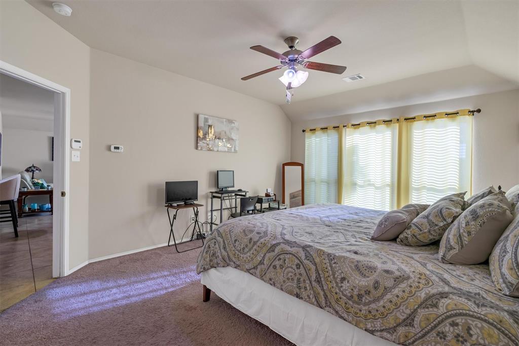 520 Rustic Oak Lane McKinney, TX 75072 - Photo 22 of 37 a bedroom with a bed and a chandelier