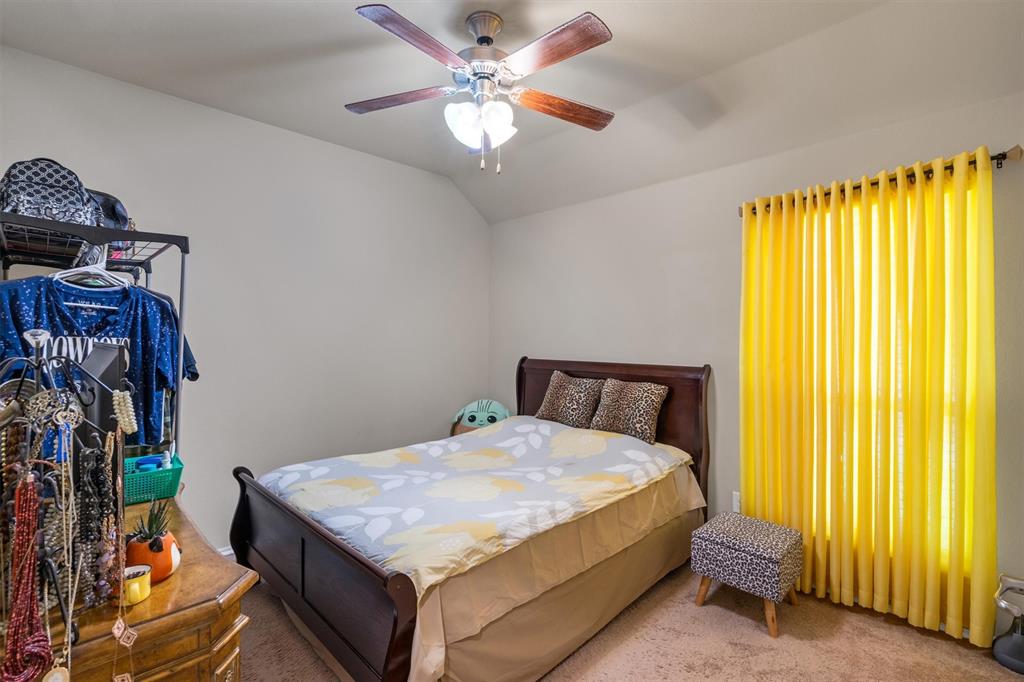 520 Rustic Oak Lane McKinney, TX 75072 - Photo 29 of 37 a bedroom with a bed and a chandelier