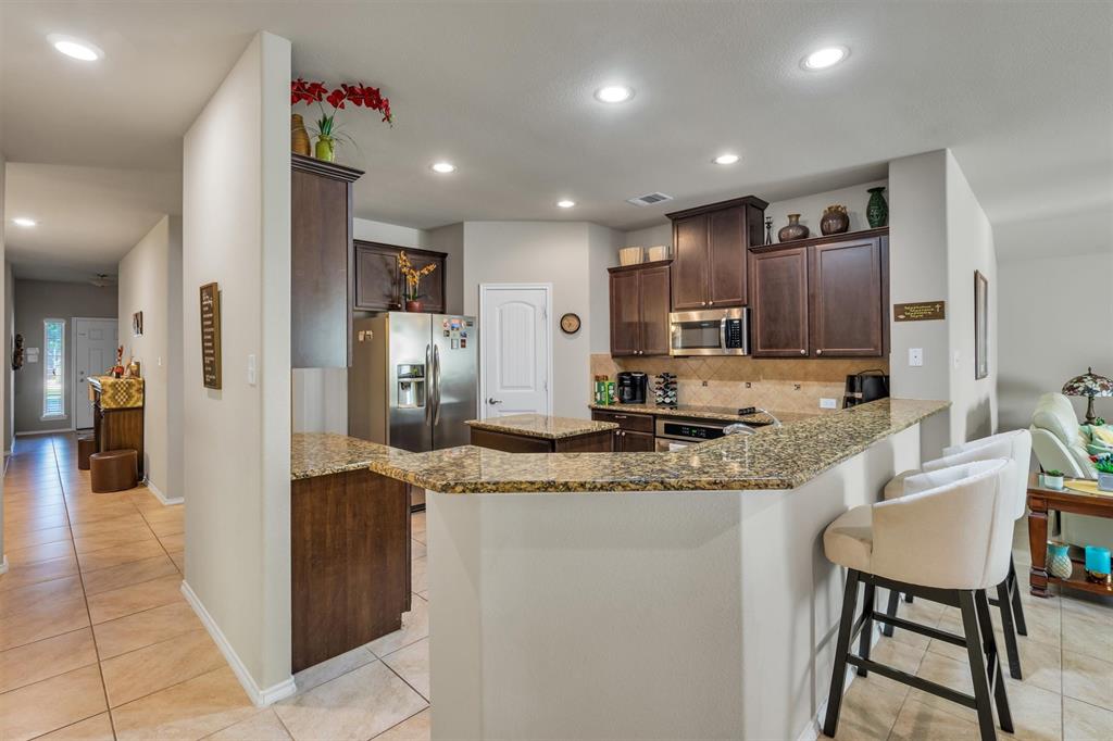 520 Rustic Oak Lane McKinney, TX 75072 - Photo 8 of 37 a kitchen with stainless steel appliances granite countertop a refrigerator and a sink