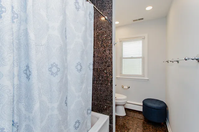 a bathroom with a toilet and a shower