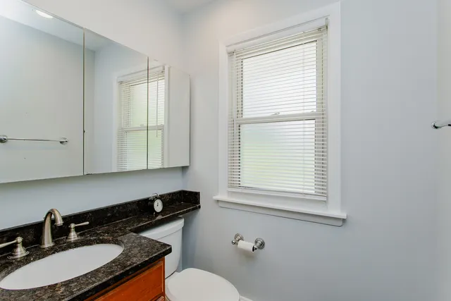 a bathroom with a sink a toilet and a window