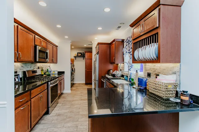 a kitchen with stainless steel appliances granite countertop a sink stove and refrigerator