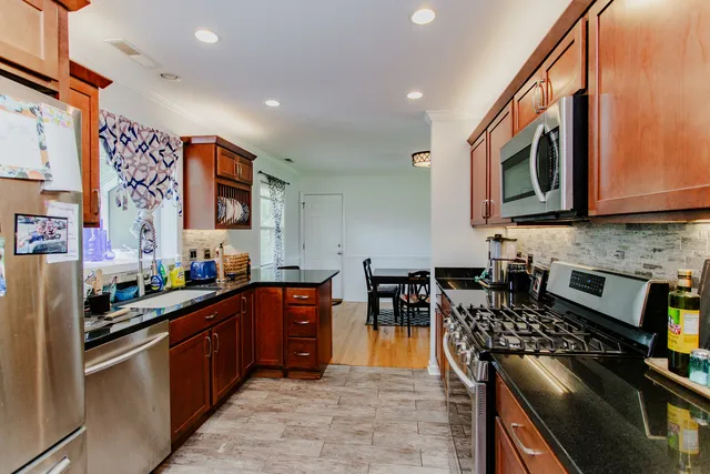 a kitchen with stainless steel appliances granite countertop a stove top oven a sink dishwasher and cabinets