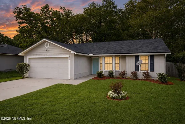 a front view of a house with a garden and yard