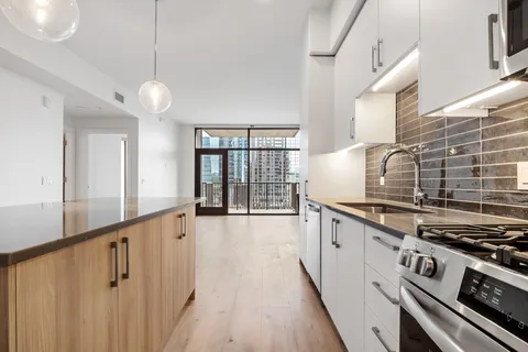 a kitchen with granite countertop a stove and a wooden floors