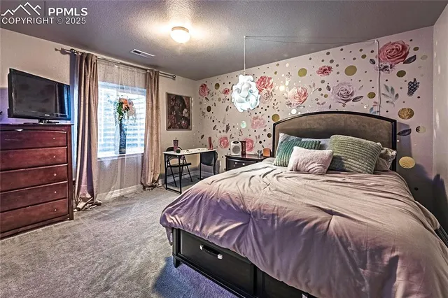 a bed sitting in a spacious bedroom next to a window