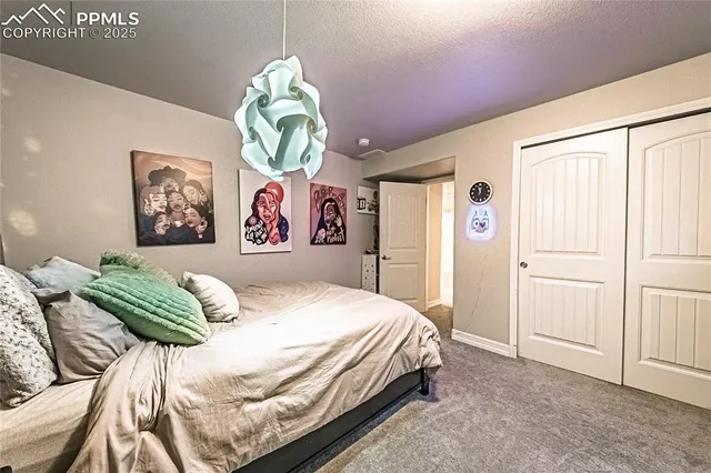 a bedroom with a bed and painting on the wall