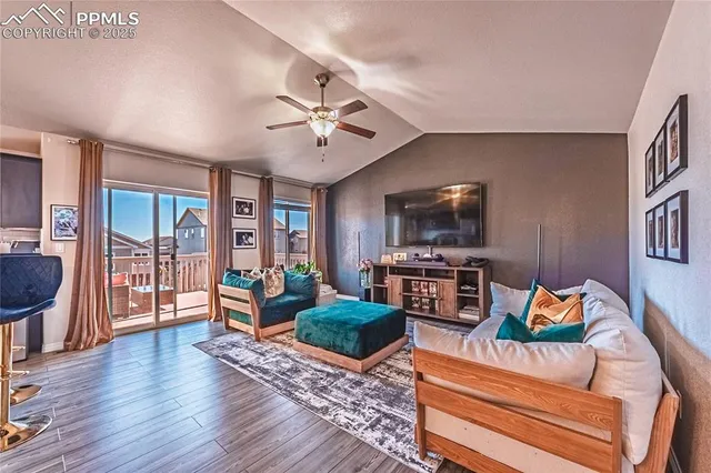 a living room with furniture a flat screen tv and wooden floor